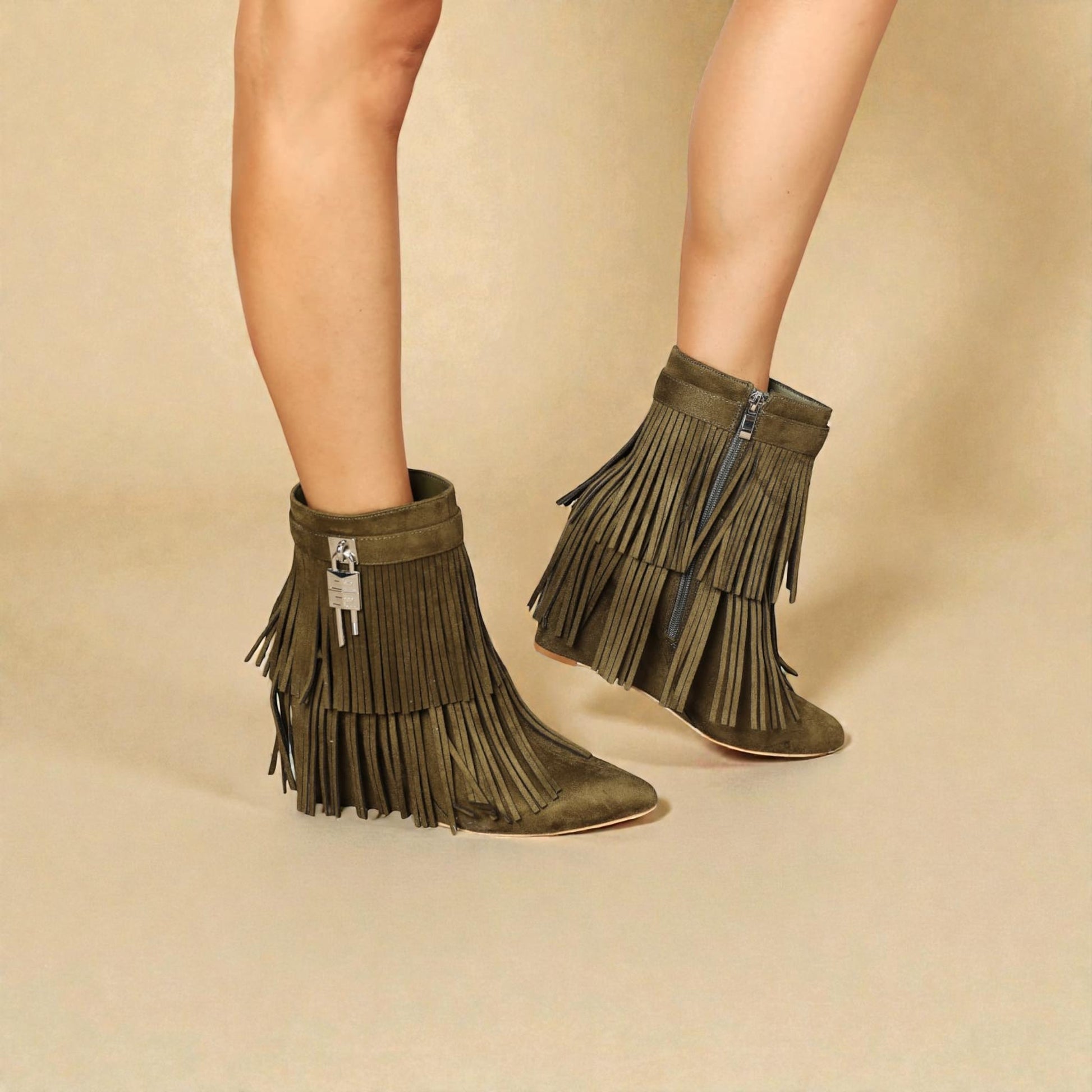 Green fringe boots worn by a person on a beige background