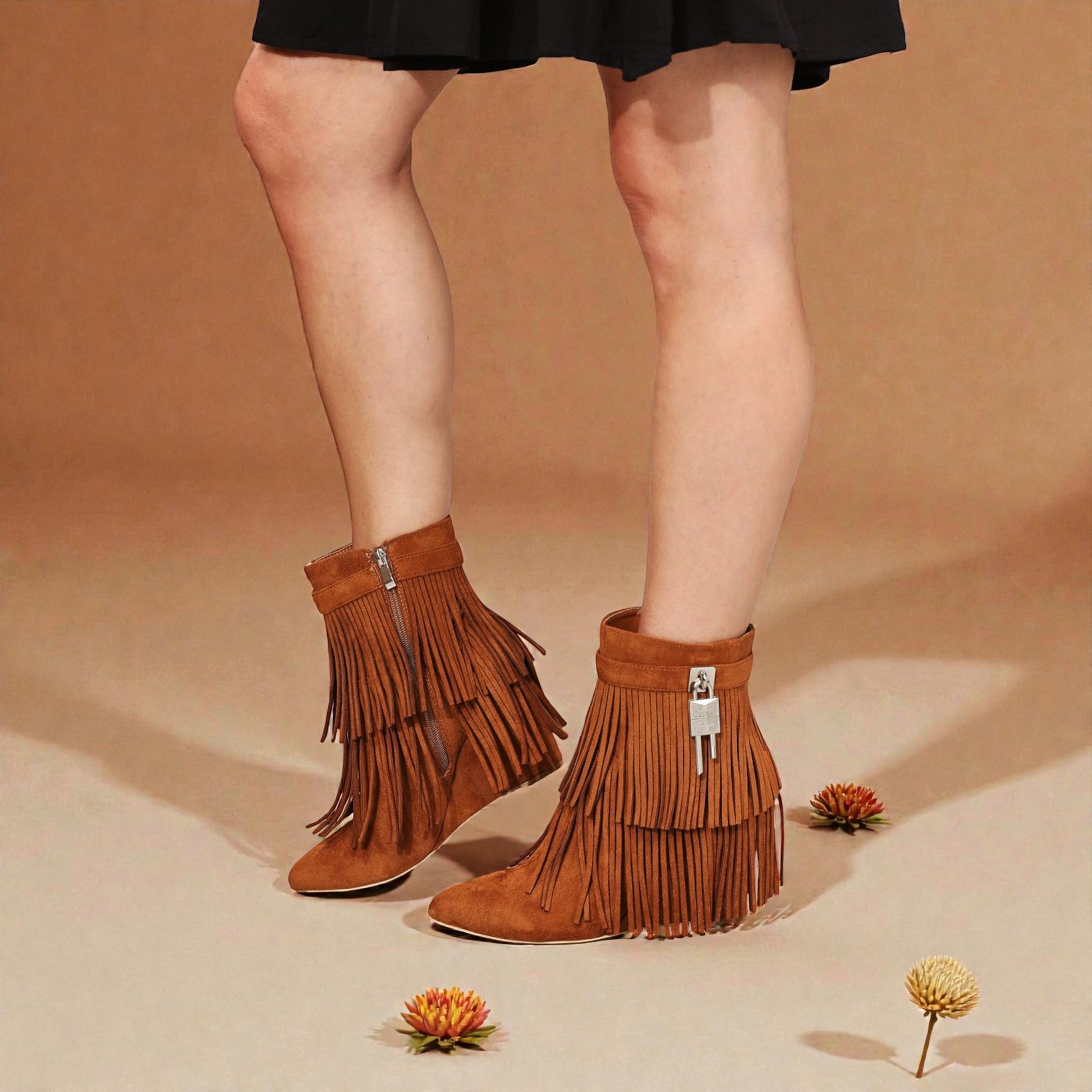 Brown fringe boots worn with a black skirt on a beige background