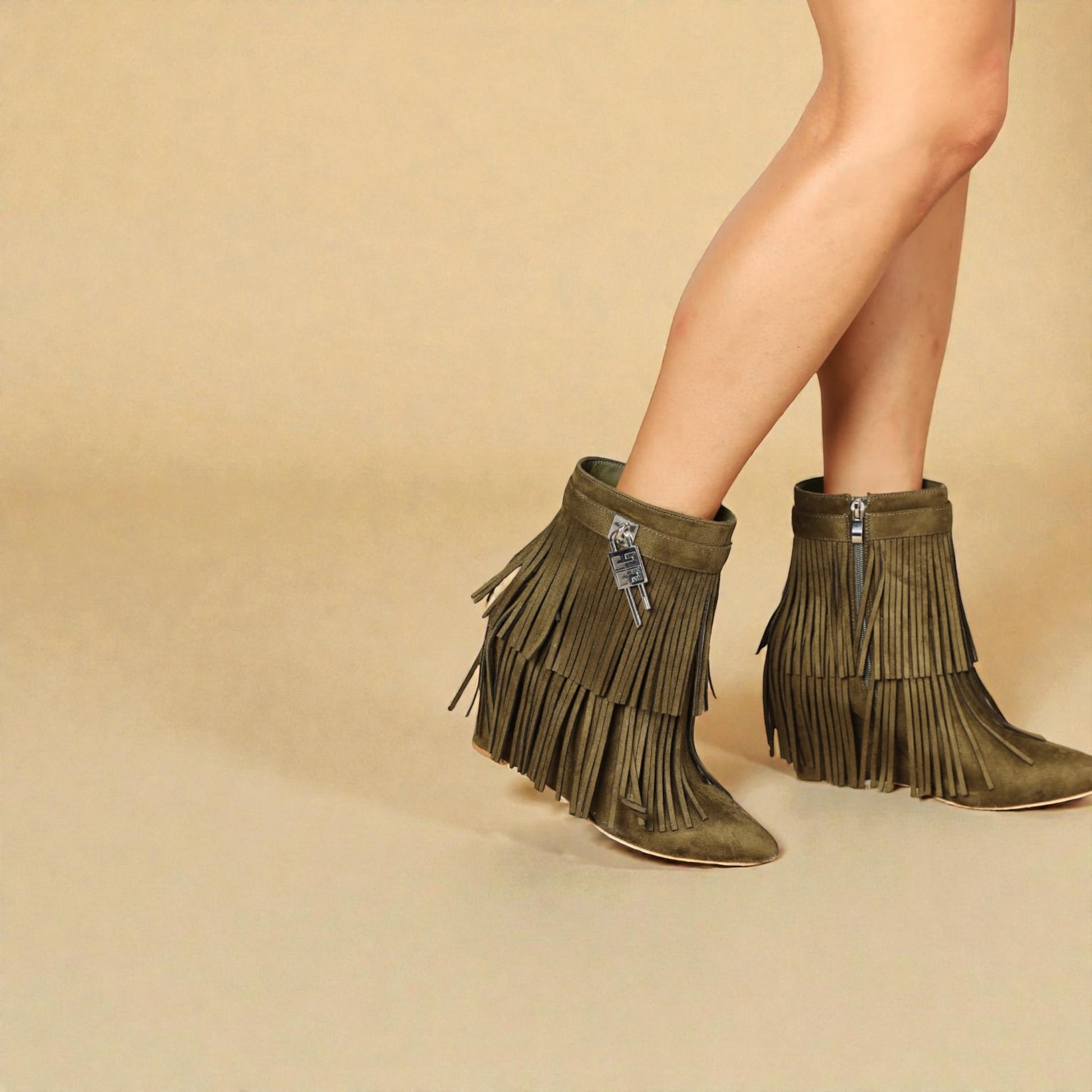 Green fringe boots worn by a person on a beige background