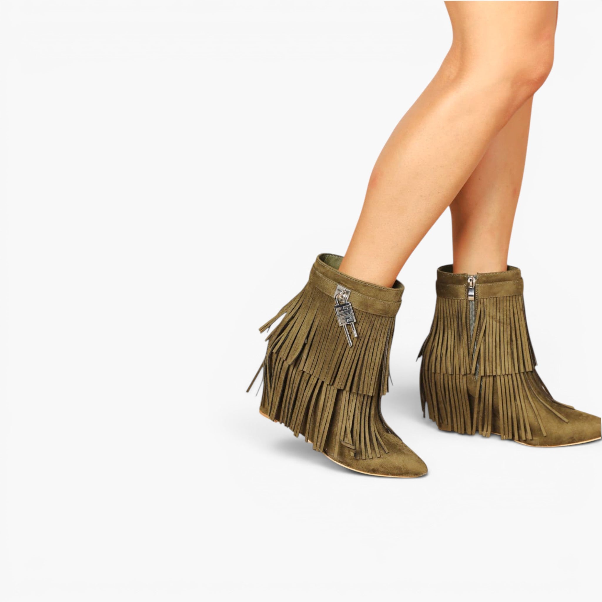 A pair of olive green fringe ankle boots with silver zipper details, shown on a model's feet against a plain white background.