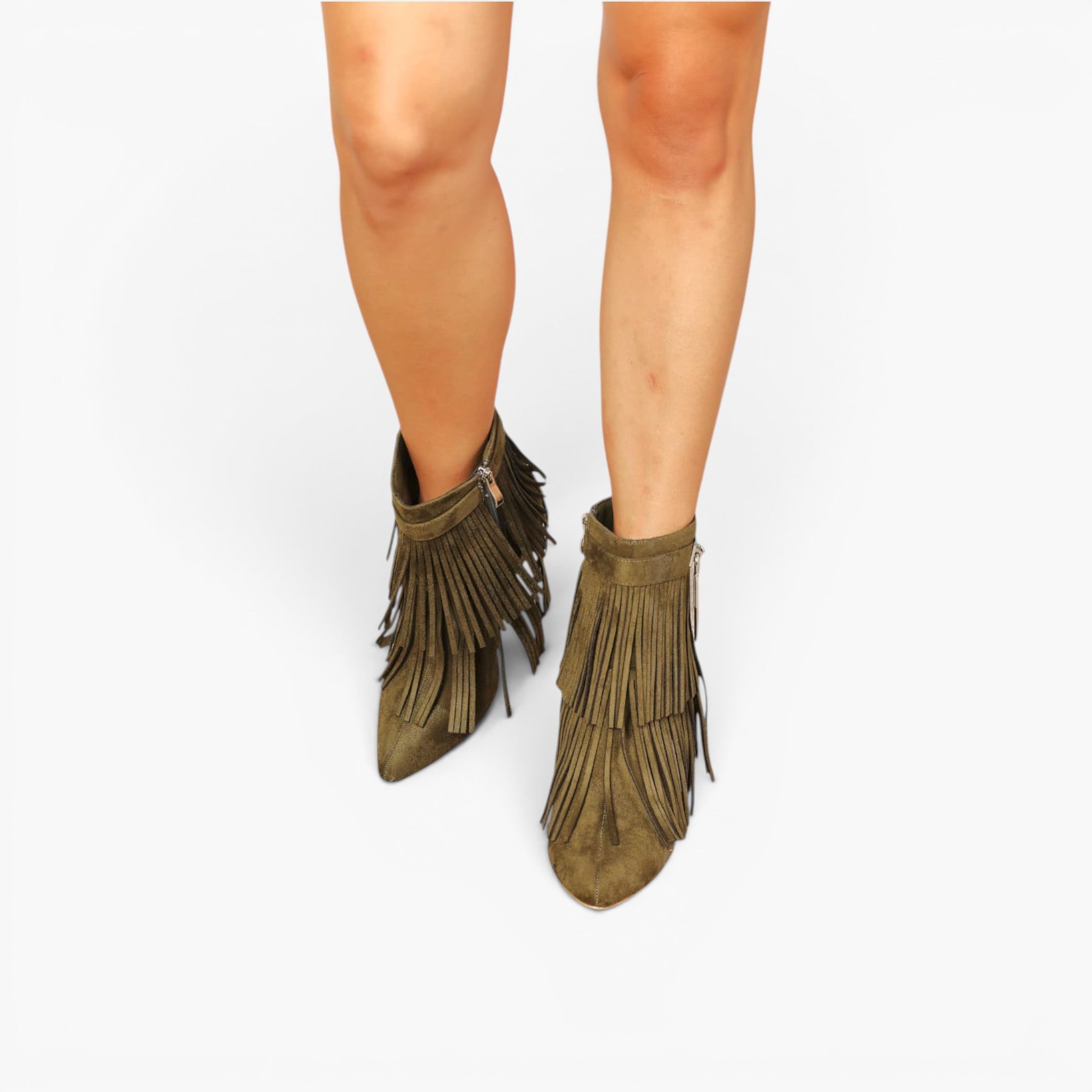A pair of olive green suede fringe ankle boots worn on a model's feet, shown from the ankle down against a plain white background.