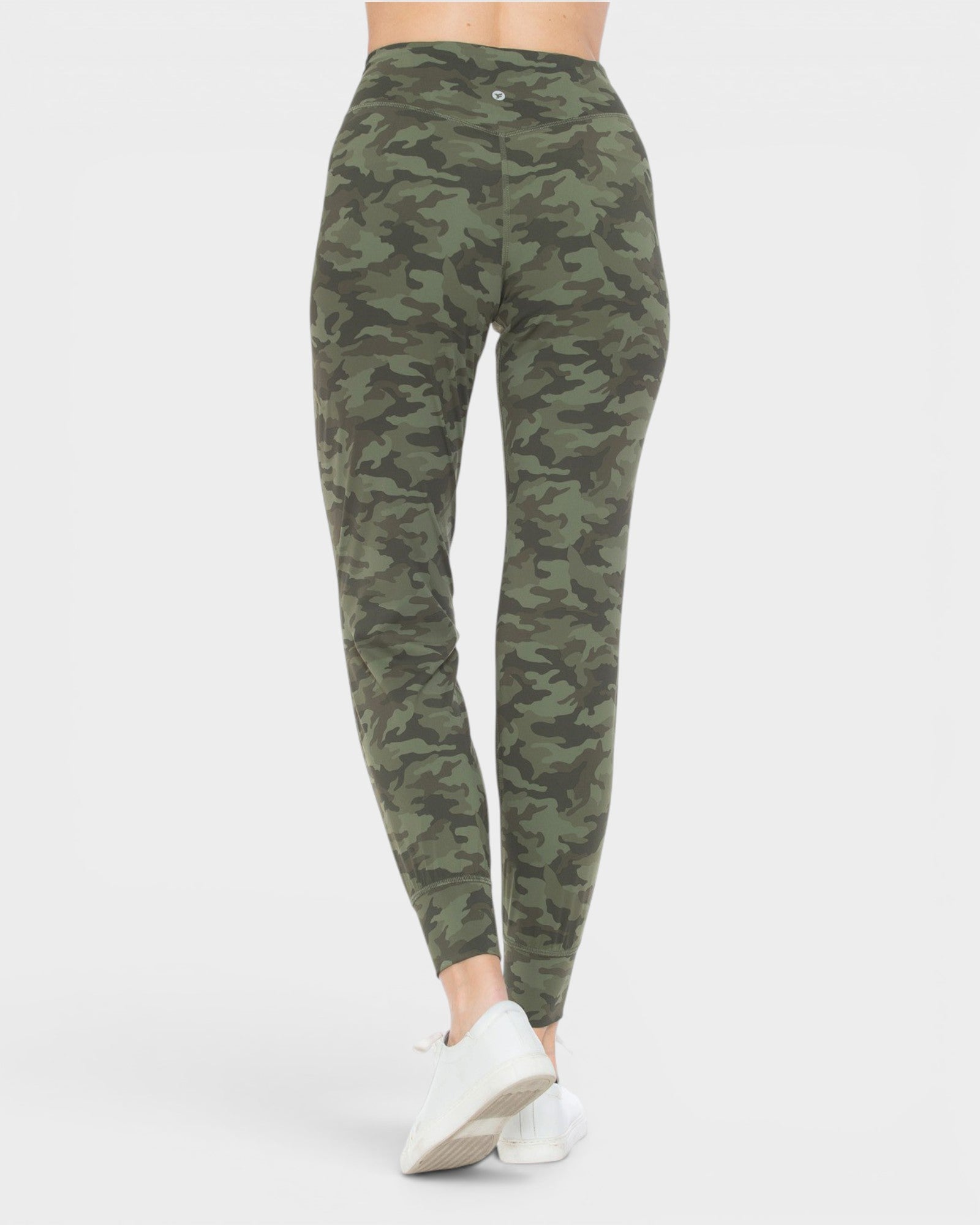 Camouflage leggings worn by a person on a white background