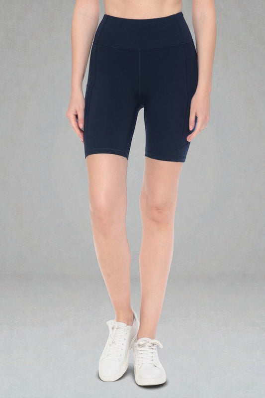 Person wearing navy blue shorts on a gray background