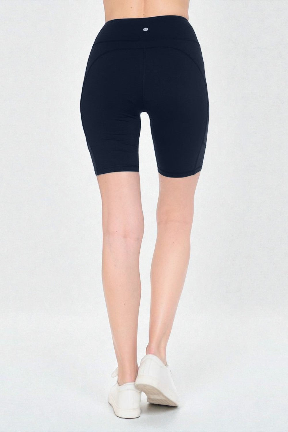 Person wearing black high-waisted shorts on a white background