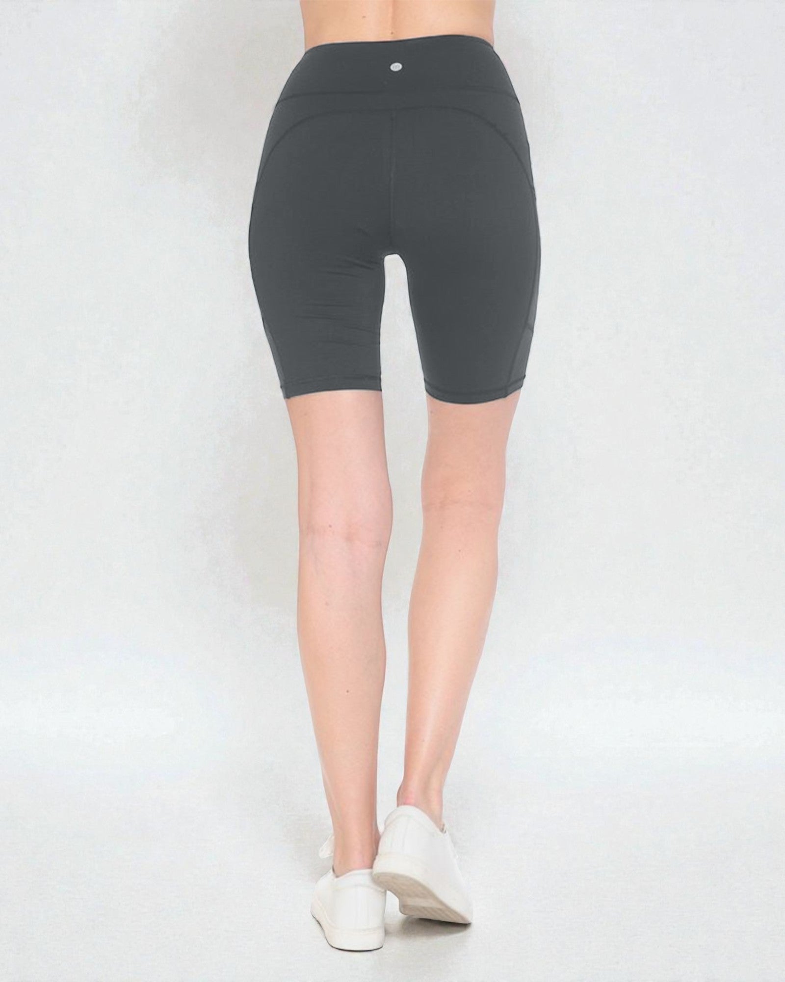 Person wearing dark gray high-waisted shorts on a white background