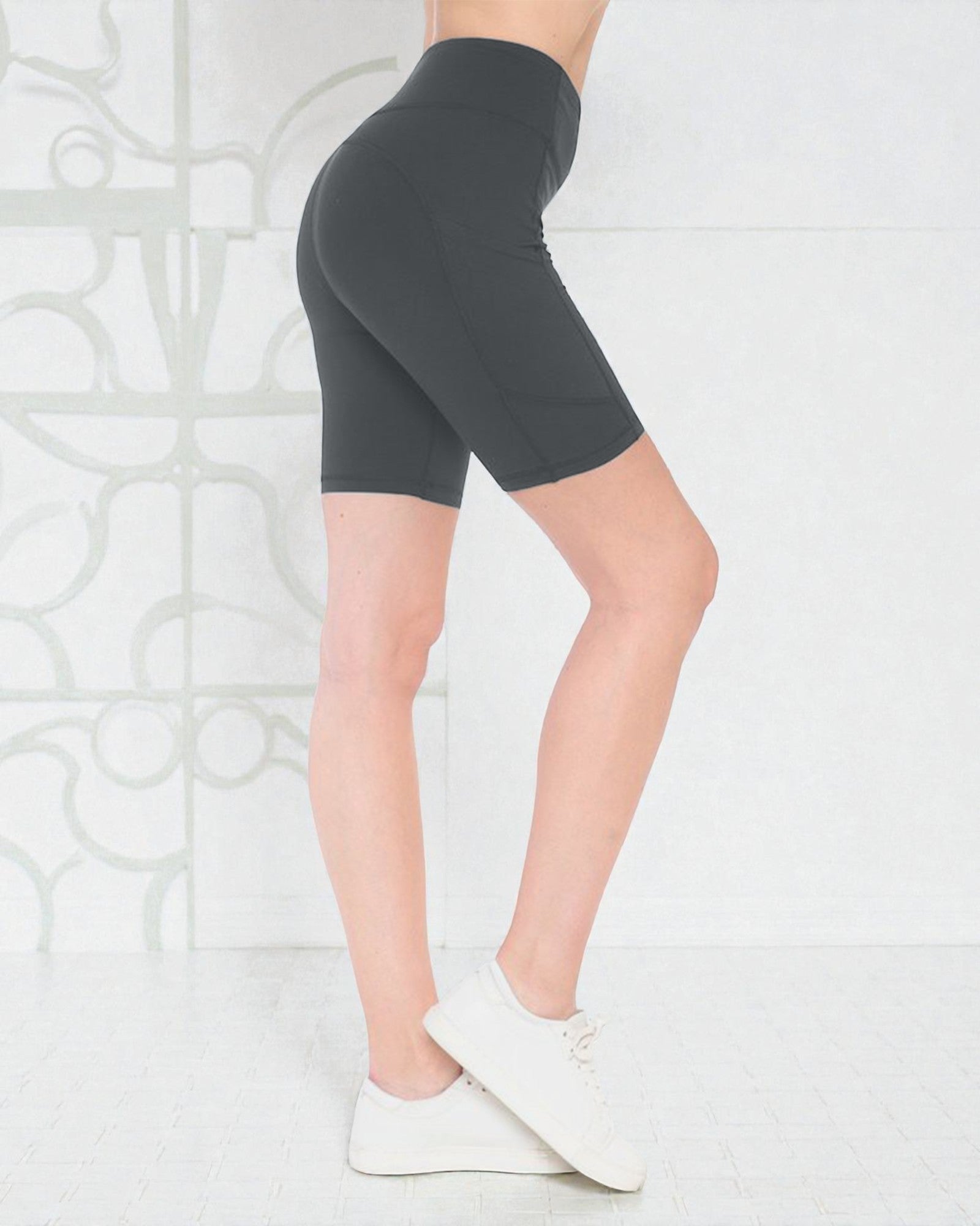 Person wearing dark gray high-waisted shorts on a light background