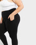Person wearing black leggings and a white top on a light gray background