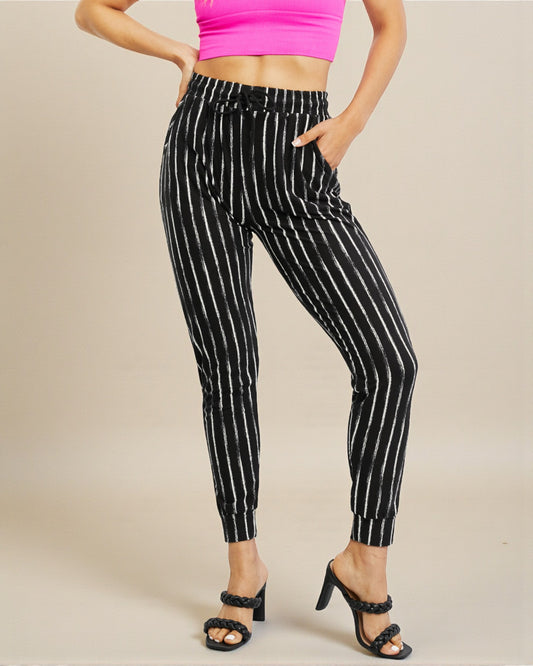 Black and white striped pants worn by a person on a beige background