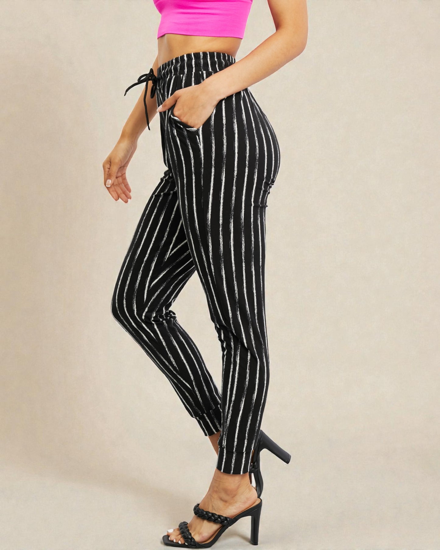 Black and white striped pants worn by a person on a beige background
