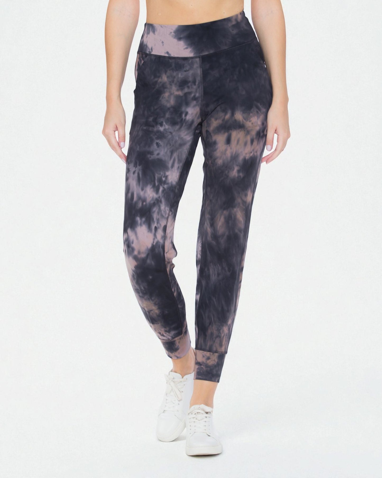 Person wearing tie-dye leggings on a white background