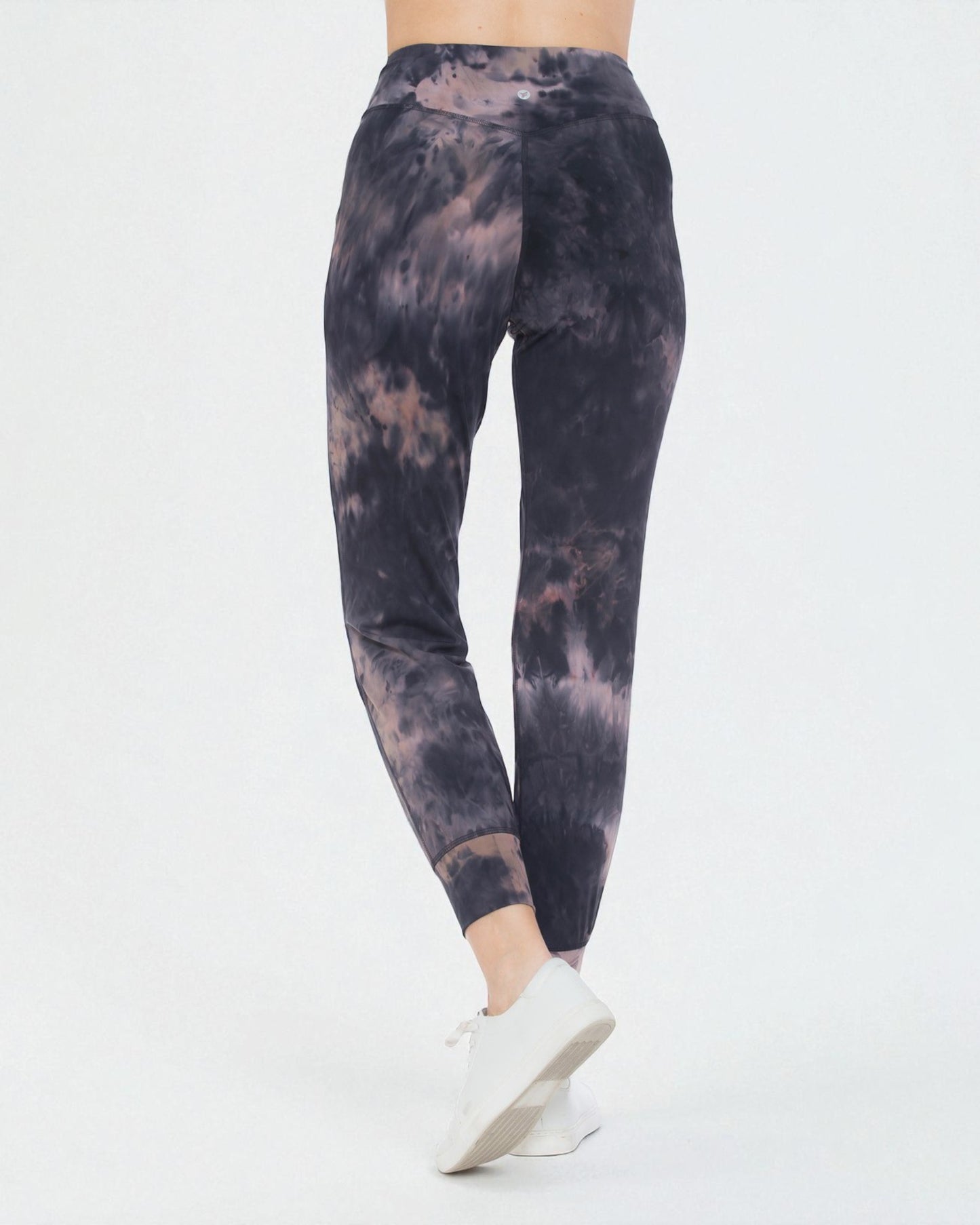 Tie-dye leggings worn by a person on a white background
