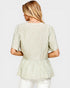 Woman wearing a light green floral blouse on a white background