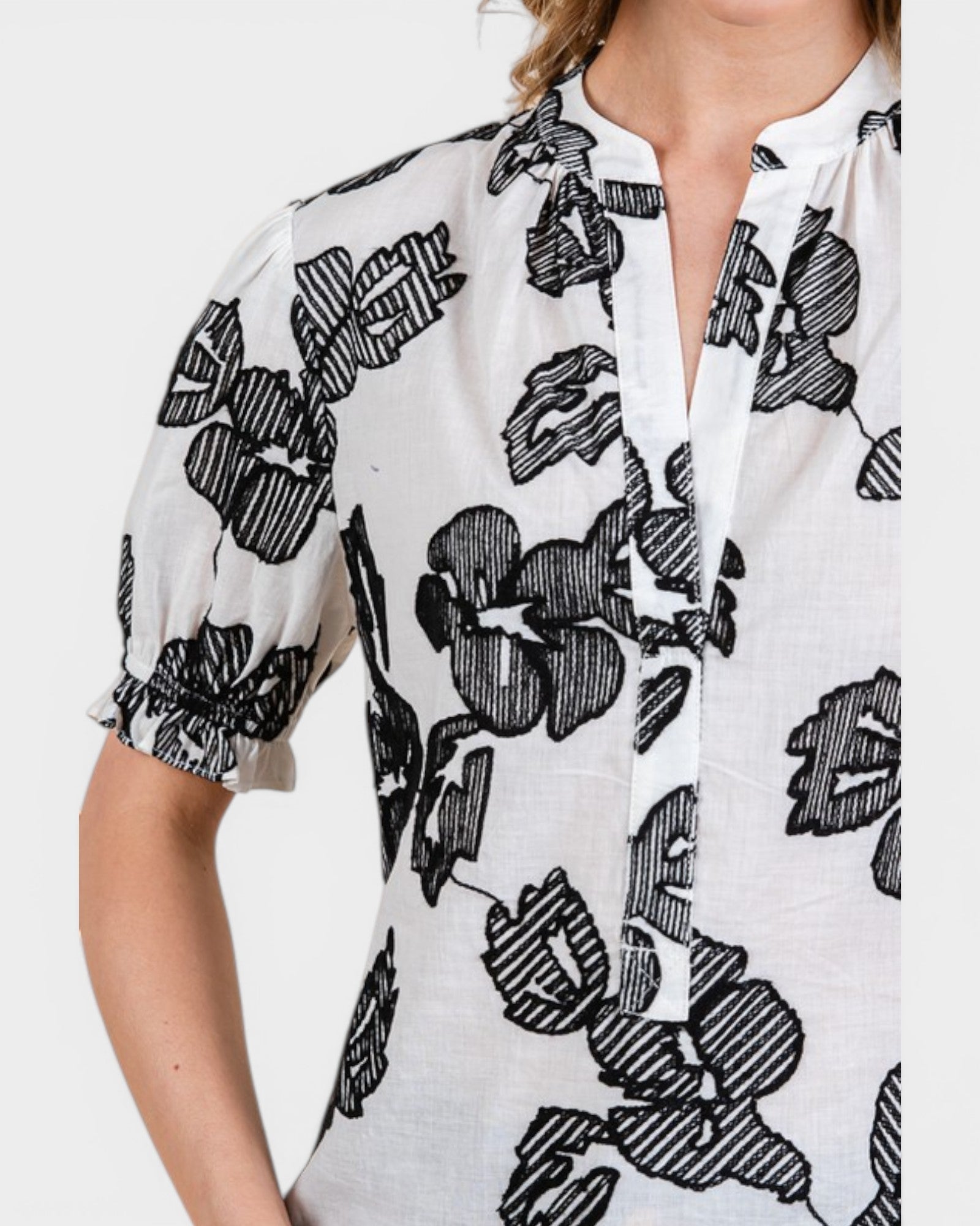 White blouse with black floral pattern on a white background