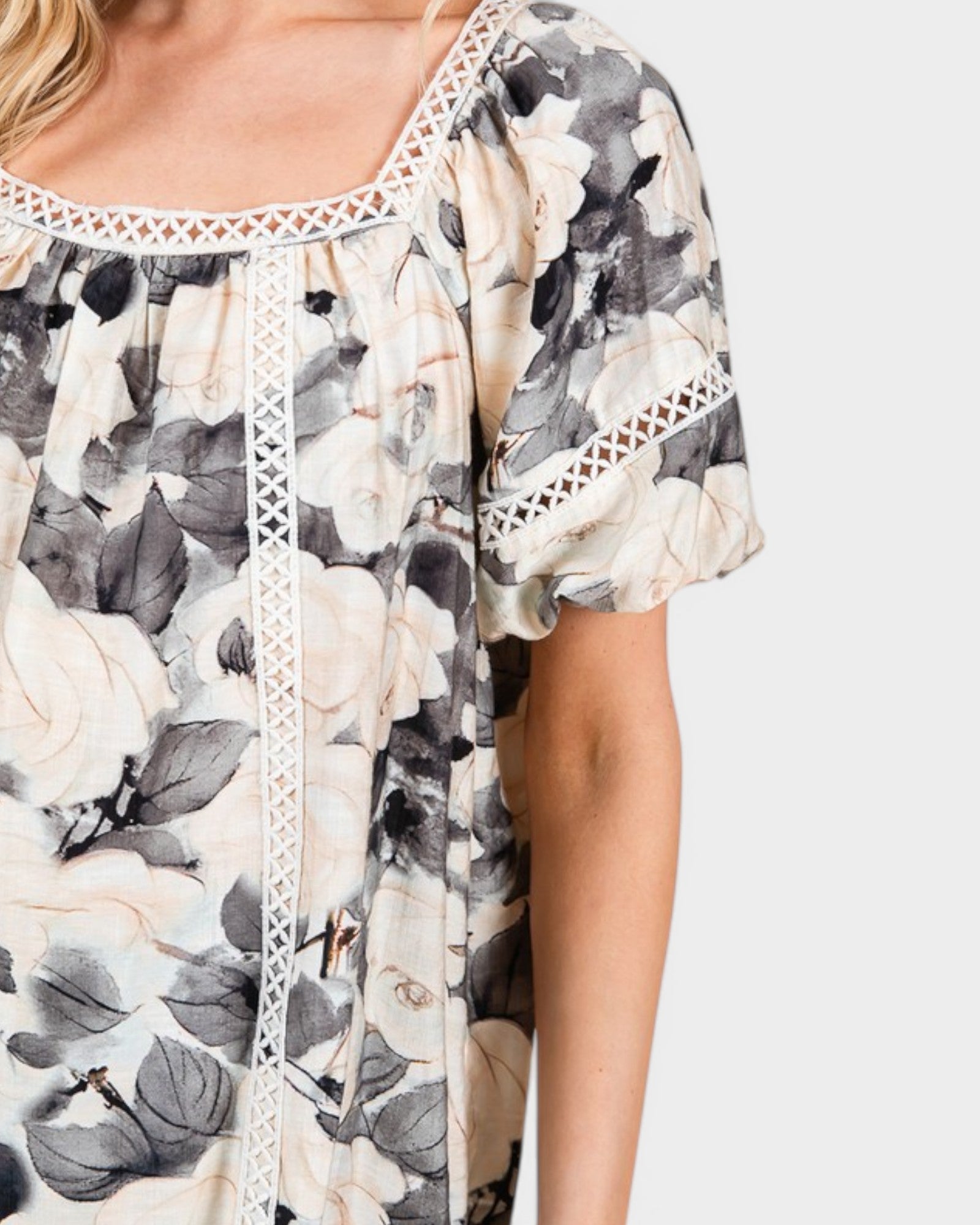 Floral patterned top with lace trim on a white background