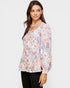 Woman wearing a floral blouse with a plain background