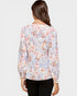 Woman wearing a floral blouse on a plain background