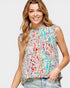 Woman wearing a colorful floral blouse against a plain background