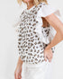 Woman wearing a leopard print top with ruffled sleeves on a white background