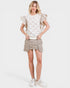 Woman wearing a white lace top and beige skirt on a white background