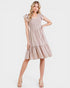 Woman wearing a beige dress with lace details on a white background