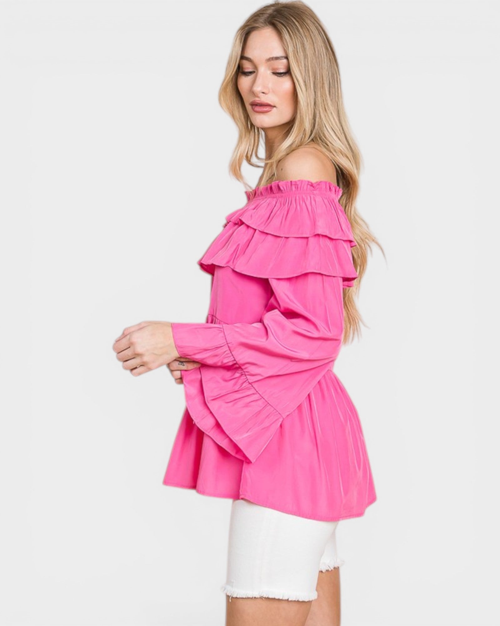 Woman wearing a pink off-shoulder top on a white background