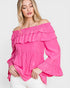 Woman wearing a bright pink off-shoulder ruffled top on a white background