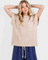 Woman wearing a beige sleeveless top with a pocket on a white background