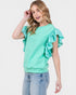 Woman wearing a mint green top with ruffled sleeves on a white background