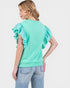 Woman wearing a light green blouse with ruffled sleeves on a white background