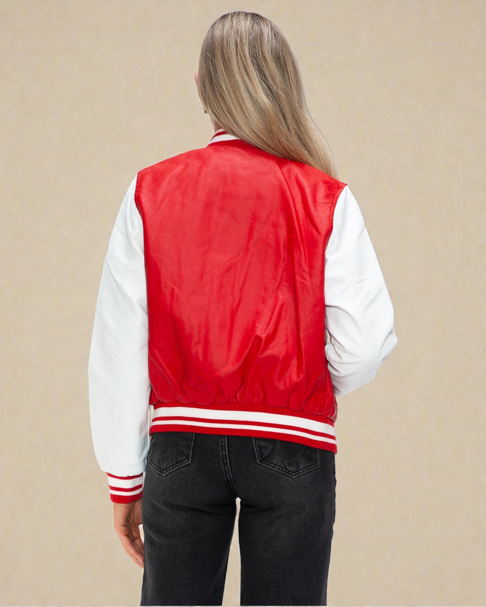 Person wearing a red and white varsity jacket on a beige background