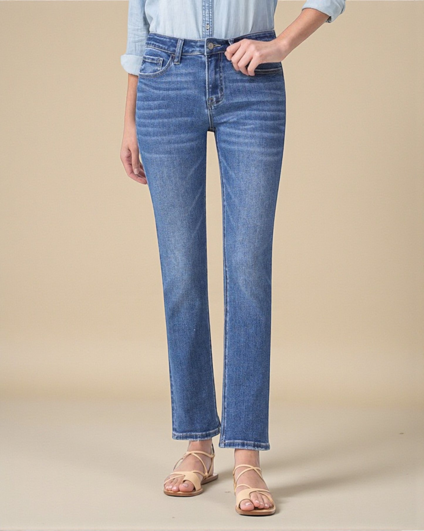 Person wearing blue jeans on a beige background