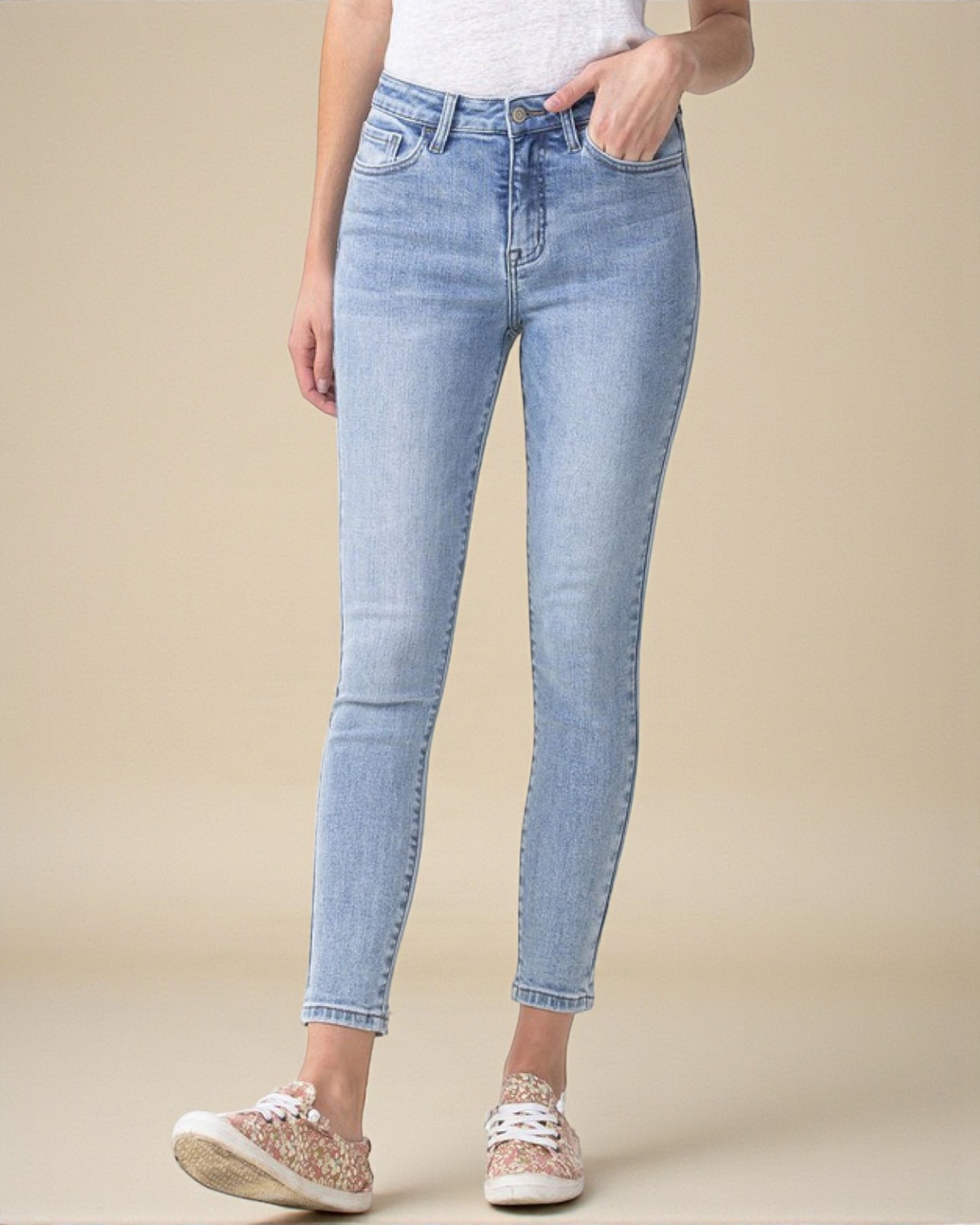 Light blue jeans worn by a person on a beige background