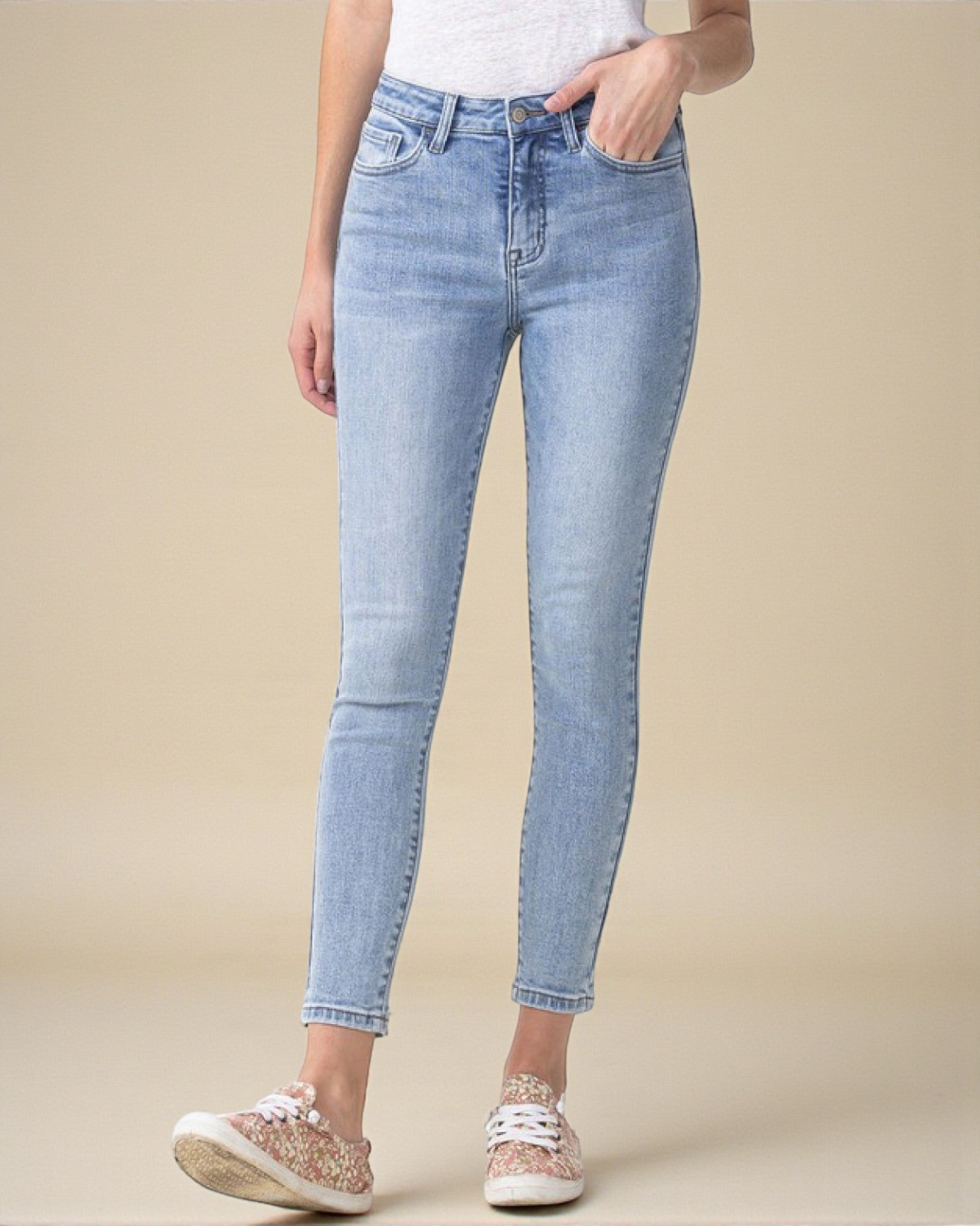 Light blue jeans worn by a person on a beige background