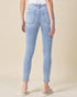 Light blue jeans worn by a person on a beige background