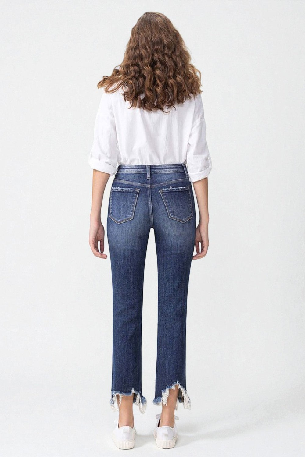 Person wearing blue jeans and a white shirt on a white background