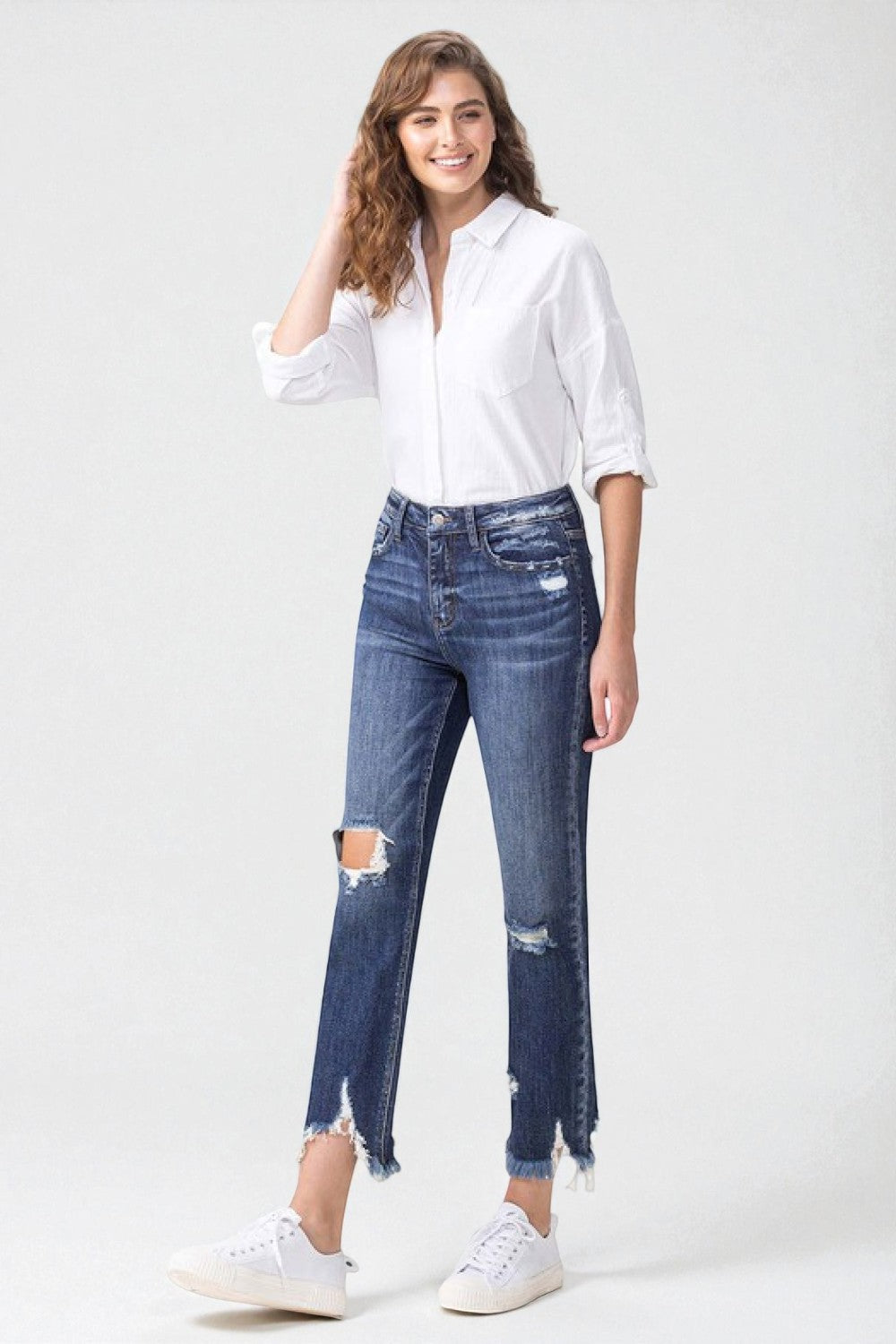 Woman wearing a white shirt and blue jeans with a white background