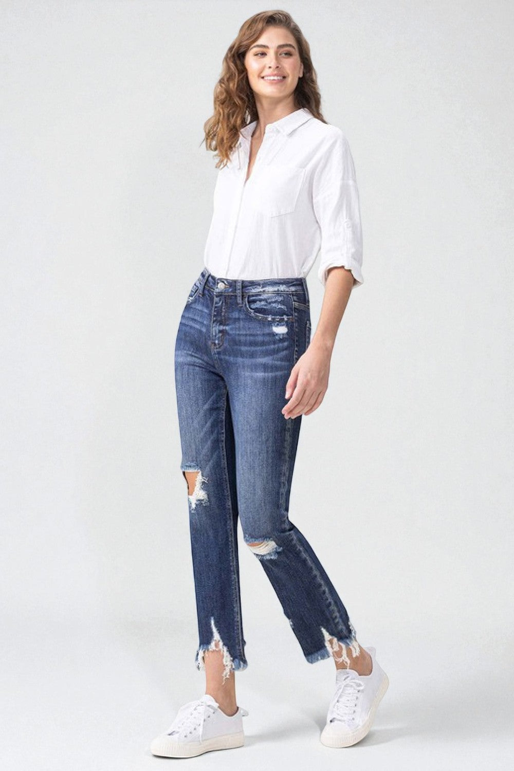 Woman wearing a white shirt and blue jeans on a white background