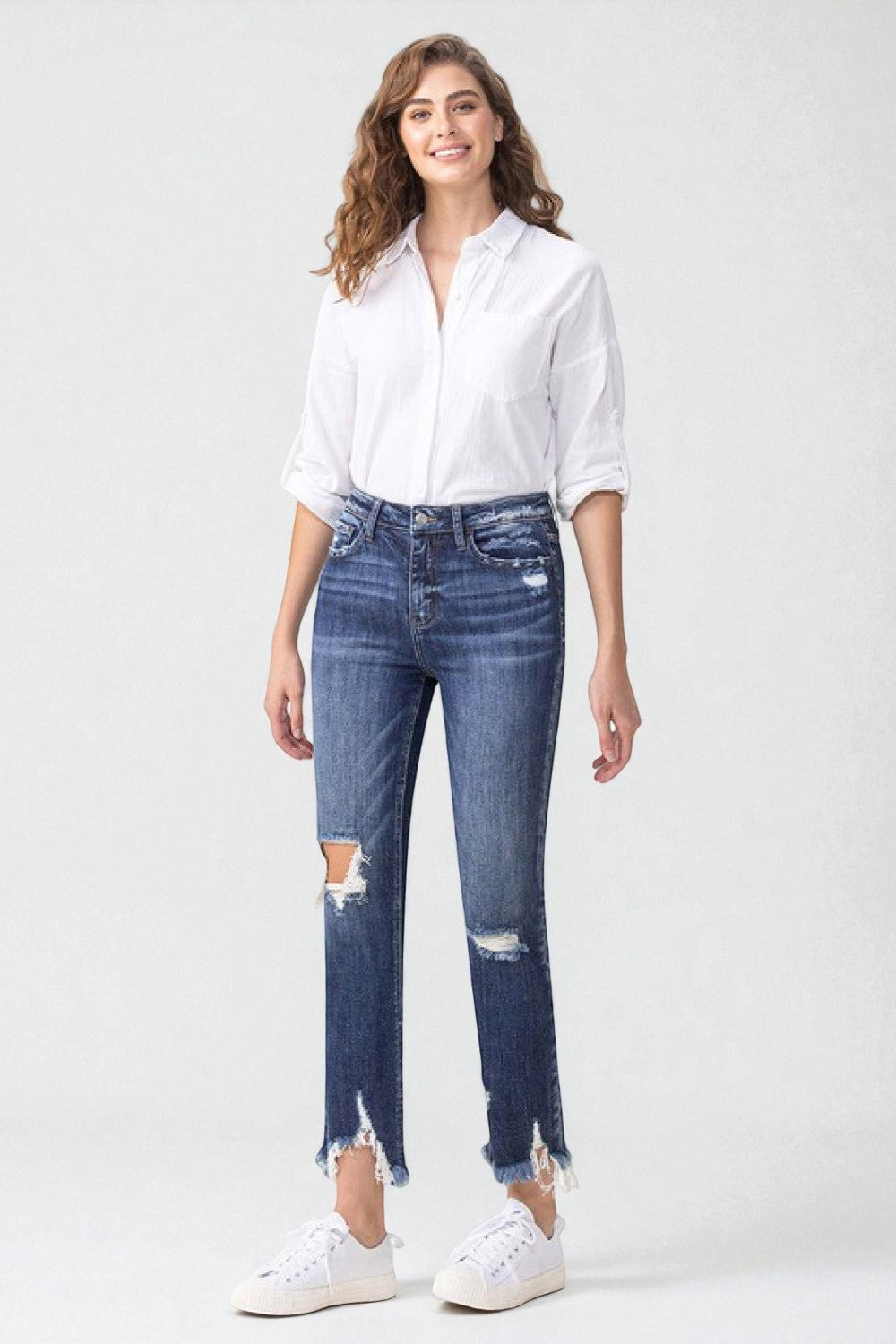Woman wearing a white shirt and blue jeans with a white background