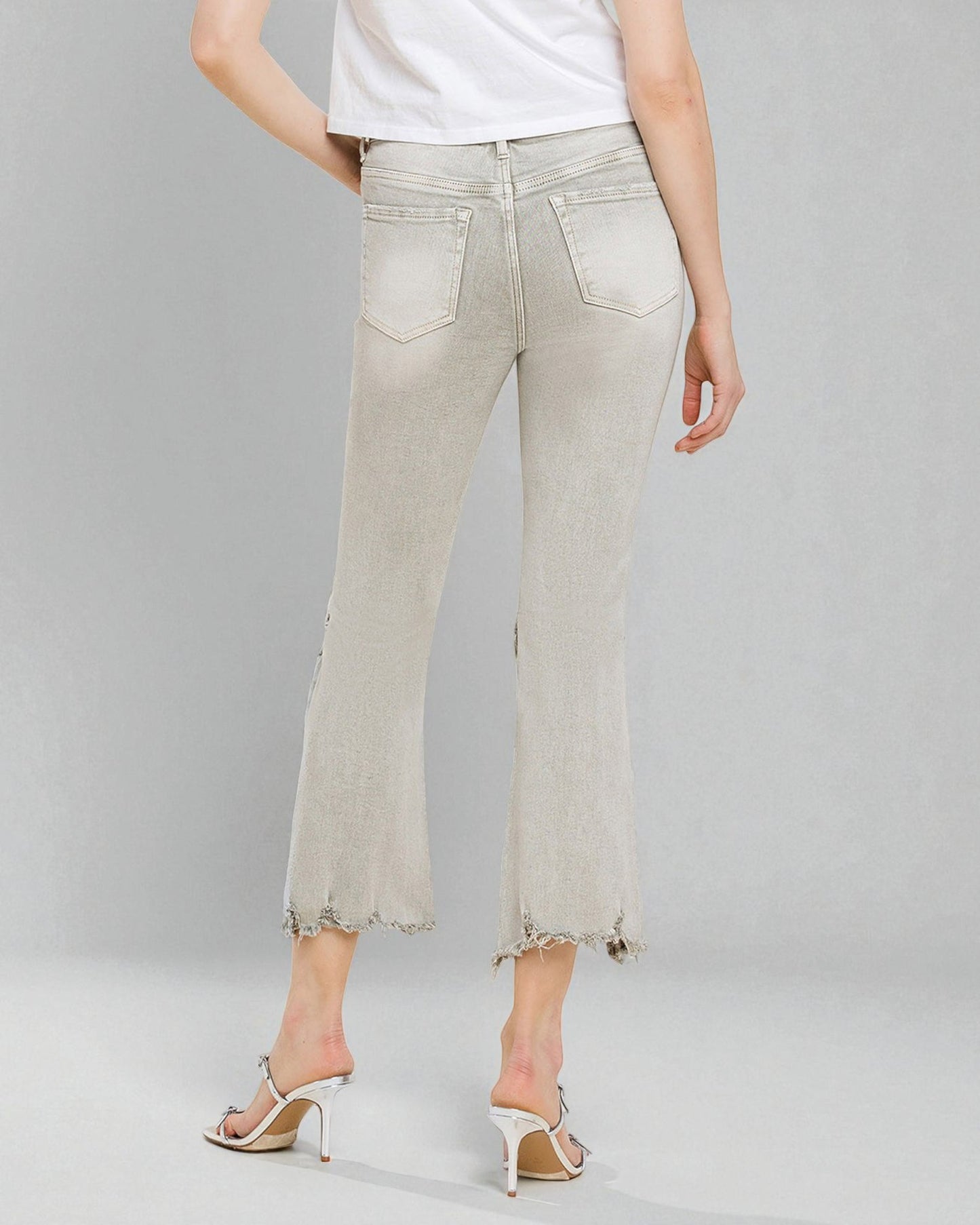 Light-colored jeans worn by a person on a gray background