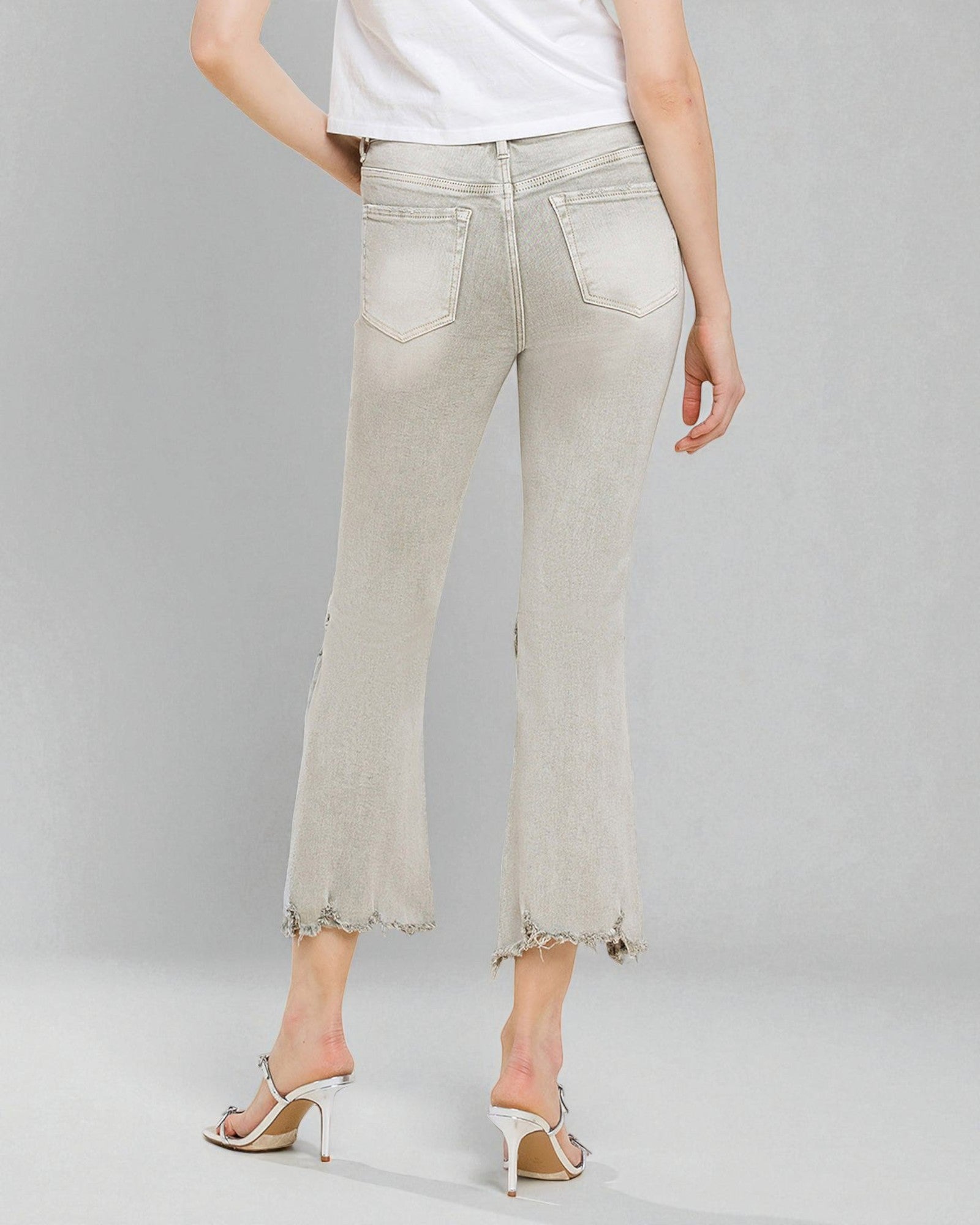 Light-colored jeans worn by a person on a gray background