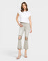 Woman wearing a white top and light gray distressed jeans on a white background