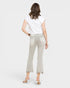 Woman wearing light gray jeans and a white top on a plain background