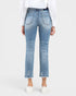 Rear view of a person wearing light-wash blue cropped jeans with a straight leg, frayed hems, and whiskering, paired with a white long-sleeve top and white slip-on shoes against a light gray studio background.