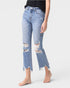 Person wearing distressed light blue jeans on a white background