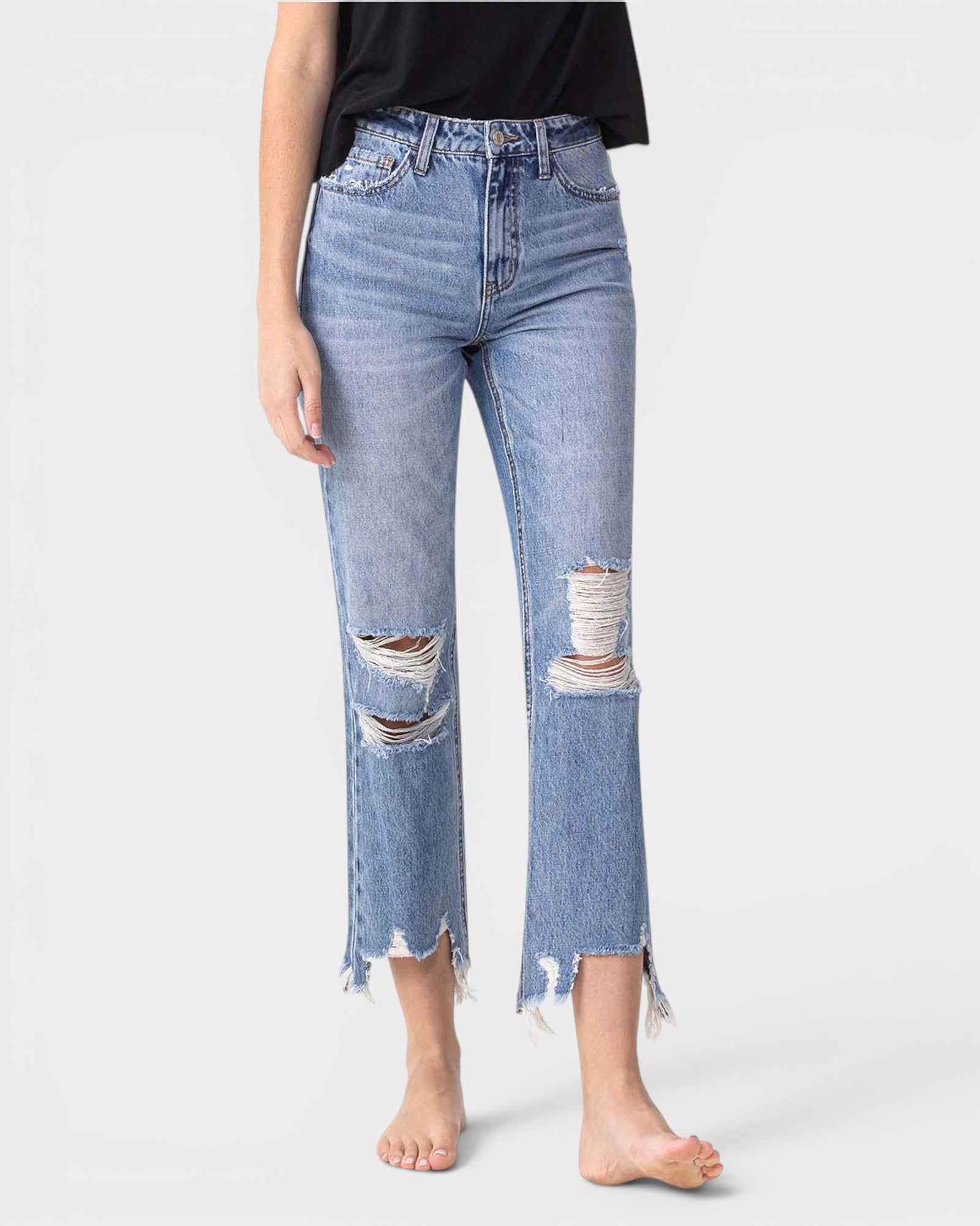 Person wearing light blue distressed jeans on a white background