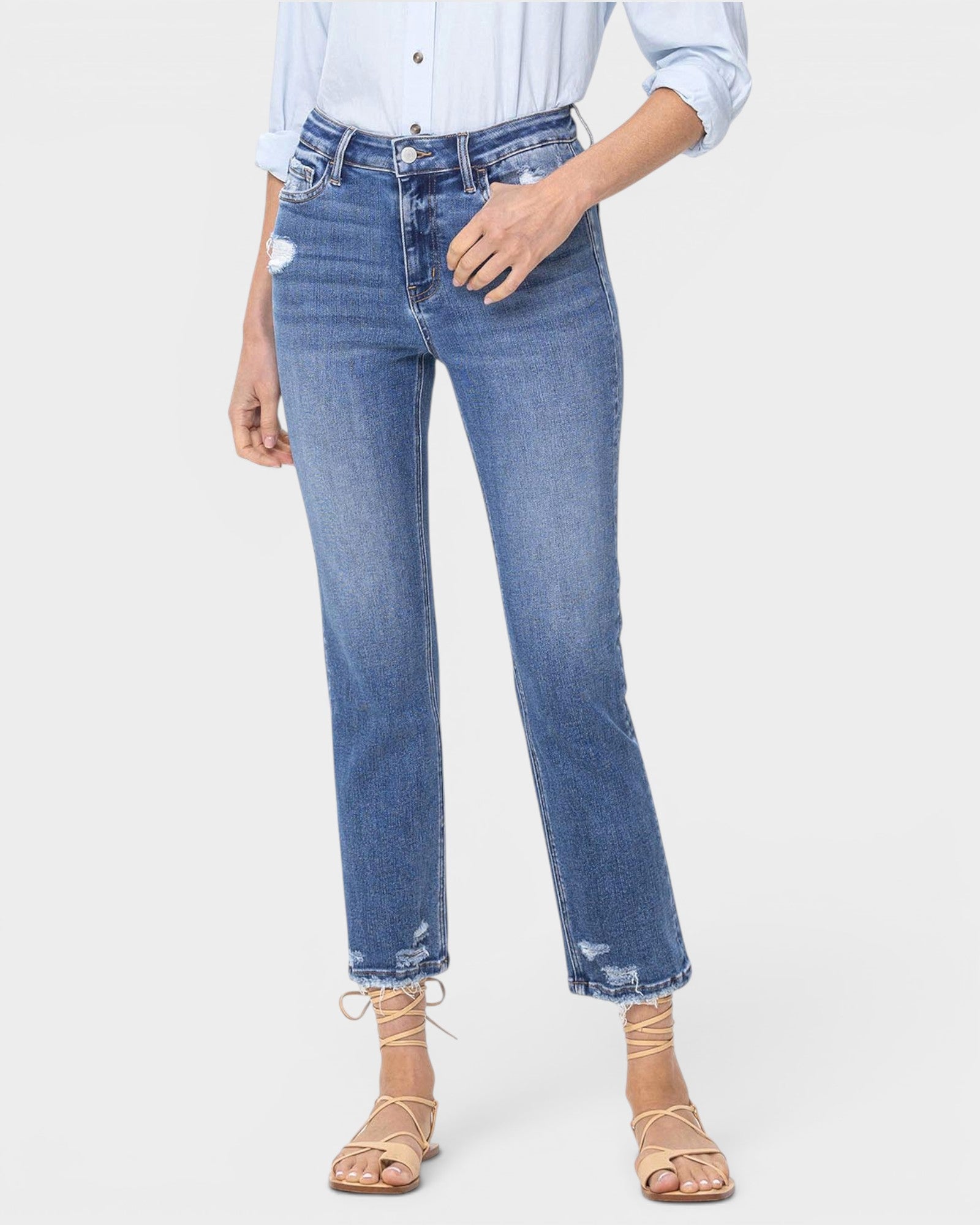 Person wearing blue jeans and a light blue shirt on a white background