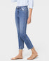 Person wearing light blue jeans and beige sandals on a white background