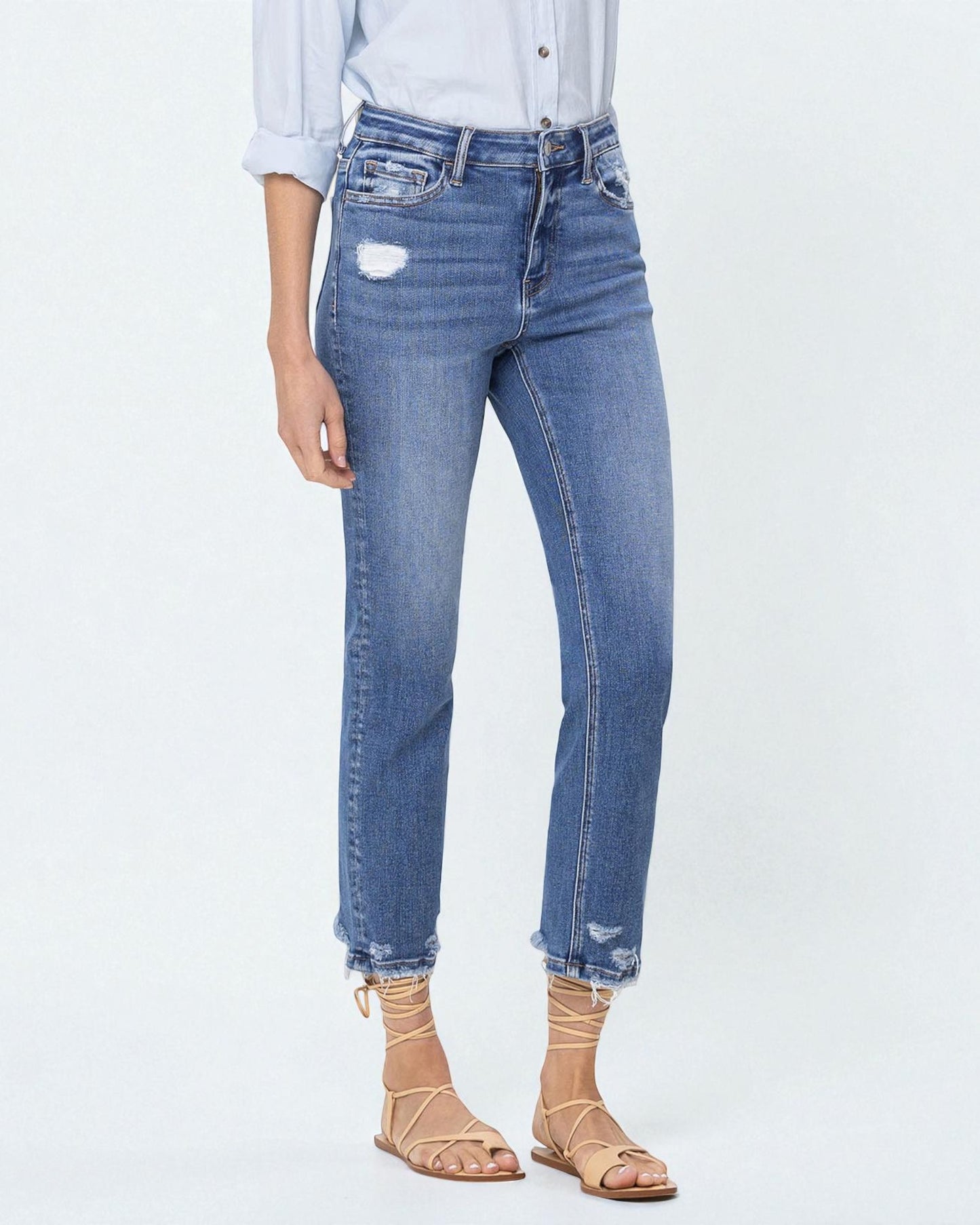 Person wearing light blue jeans with a white background