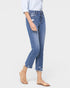Person wearing light blue jeans and beige sandals on a white background