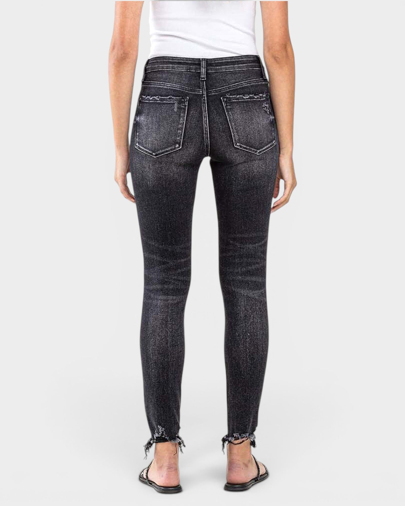 Black jeans worn by a person on a white background